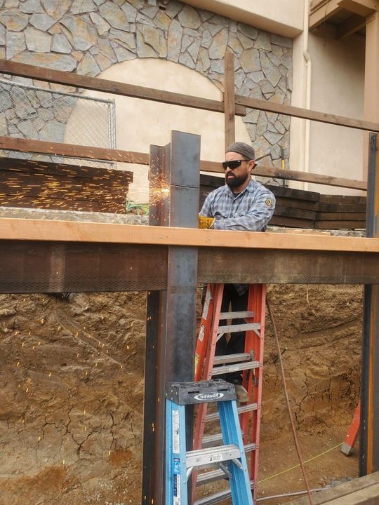 Mobile welding for wall-mounted steel beams and support framing.