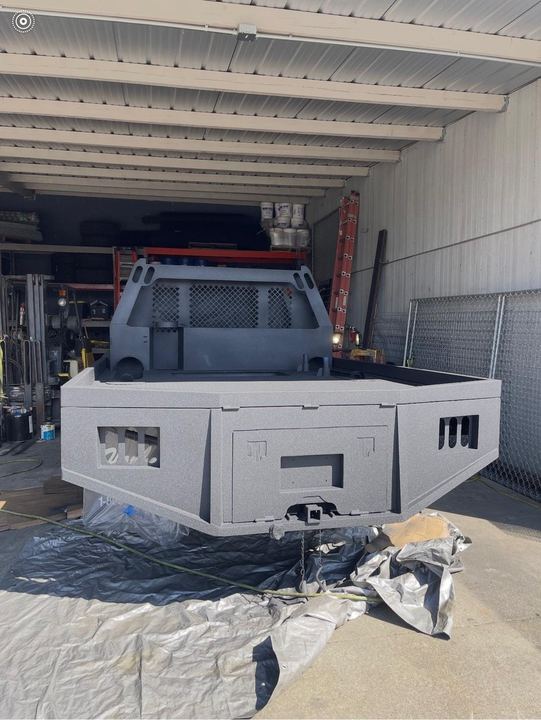 Custom fabricated flatbed truck body with welded steel framing, storage, and deck details.