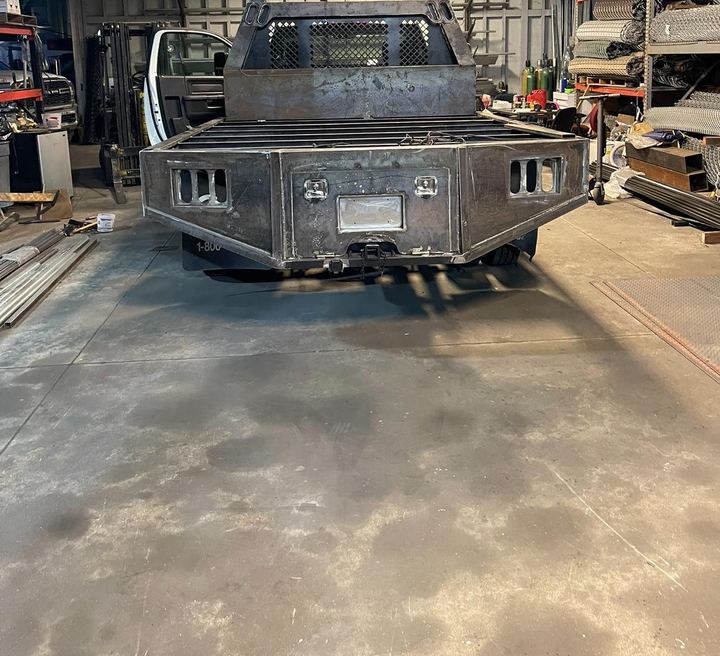 Custom flatbed truck fabrication with welded frame, deck, and steel body details.