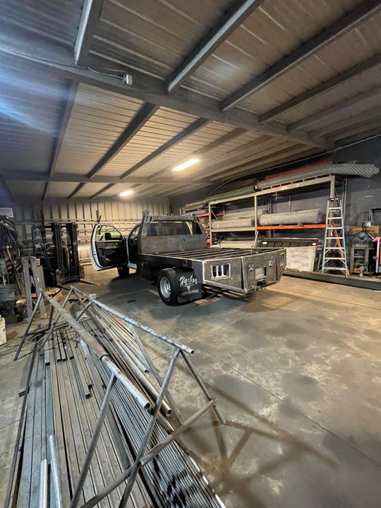 Flatbed truck fabrication and welding with custom steel frame and deck work.